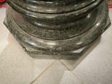 a clock sitting on top of a marble pedestal