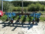 une charrue bleue posée dans la terre