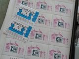 de nombreux timbres posés sur une table, à côté d'une calculatrice et d'une autre calculatrice