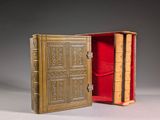 an open book sitting on top of a table next to a red case