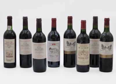 six bottles of wine are lined up in a row on a white surface