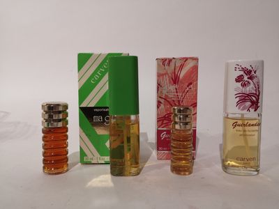 Quatre parfums différents sont alignés sur une table
