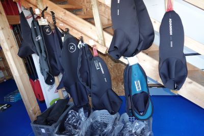plusieurs combinaisons suspendues à un portant dans une pièce
