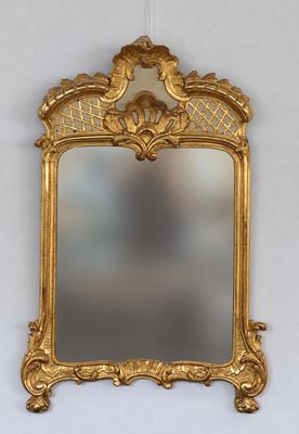 une image d'un miroir encadré d'or accroché à un mur