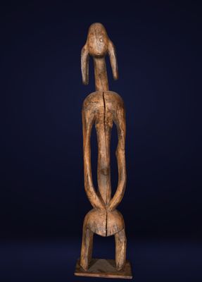 a wooden statue of a woman with a long neck and a long tail