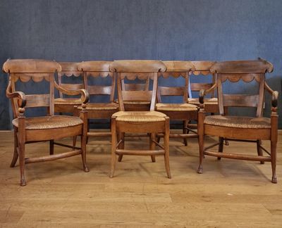 six chaises en bois sont alignées en rang contre un mur bleu