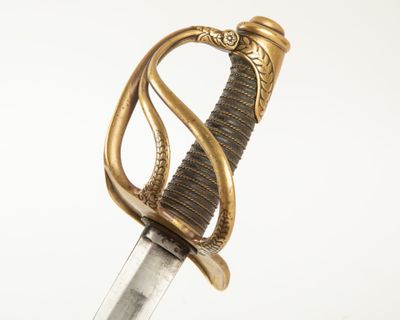 une vieille épée avec un manche en or sur fond blanc