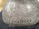 a silver vase sitting on top of a black table