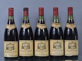 six bottles of wine are lined up in a row on a table