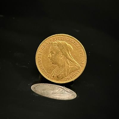 une pièce d'or et une pièce d'argent posées sur une surface noire