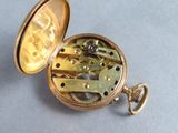 a gold pocket watch with a chain attached to it