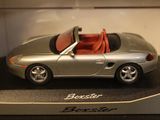 a silver toy car with a red top in a display case