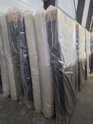 many mattresses wrapped up in plastic in a warehouse