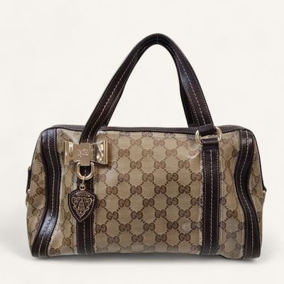a brown and black handbag sitting on top of a white surface