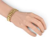a close up of a person ' s hand wearing a gold bracelet