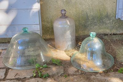 trois cloches en verre posées par terre les unes à côté des autres