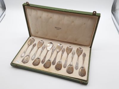six cuillères dans un étui vert posé sur une table blanche