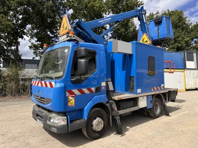 un camion bleu garé sur la terre battue