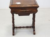 an old wooden table with a glass top on a white floor