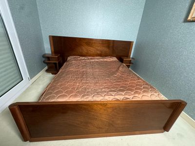 un lit avec une tête et un pied de lit en bois dans une chambre