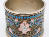 a close up of a ring with flowers on it on a white surface