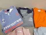 a pile of polo shirts sitting on a couch next to each other
