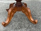 a wooden table with a glass top on a gravel ground