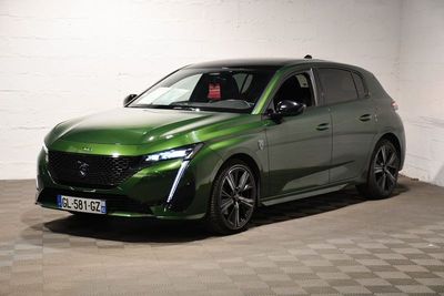 La voiture verte est garée dans une pièce dont le sol est en damier.