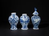 three blue and white vases sitting next to each other on a black surface