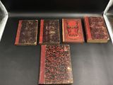 six vieux livres sont alignés dans une vitrine