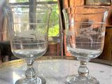 two wine glasses sitting on a table in front of a window
