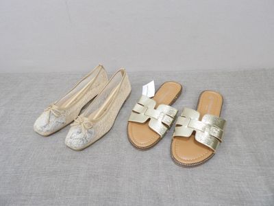two pairs of shoes are sitting on a bed next to each other