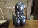 a statue of a woman sitting on top of a wooden table