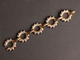 gros plan d'un bracelet en or sur une surface noire