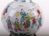 a white vase with a picture of people on it