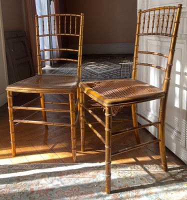two wooden chairs sitting next to each other in a room