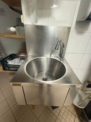 a stainless steel sink in the corner of a kitchen