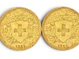 quatre pièces d'or sont alignées sur une surface blanche
