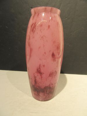 a pink vase sitting on a table with a black background