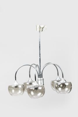 Lustre chromé à trois lumières avec des abat-jours en verre sur fond blanc