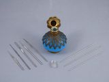 a small blue vase with needles on a white table
