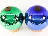 pair of blue and green christmas ornaments on a white surface