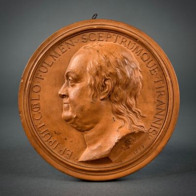 a close up of a bronze medal with a man ' s face on it