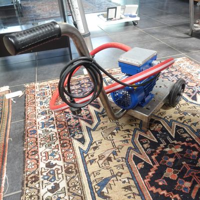 une machine à nettoyer les moquettes posée sur un tapis dans une pièce