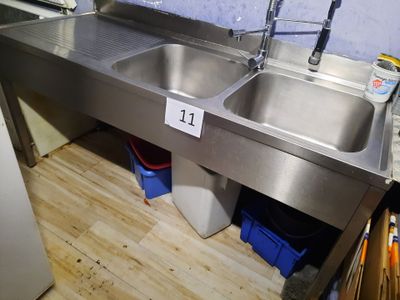 a stainless steel sink and a refrigerator in a kitchen