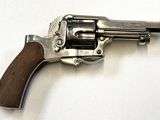 pistolet posé sur une surface blanche, muni d'une crosse en bois