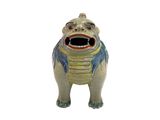 une figurine en céramique représentant une grenouille la bouche ouverte