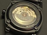 a close up of a watch on a black surface