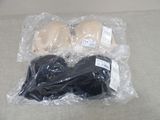 two bras wrapped in plastic on the floor