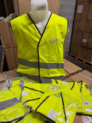 un mannequin portant un gilet de sécurité jaune à côté d'une pile de cartons